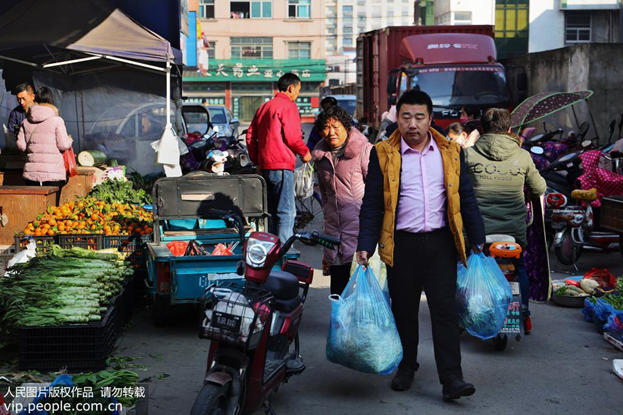 12月10日，郭峰在从群楼村菜场买完蔬菜返回的路上。 