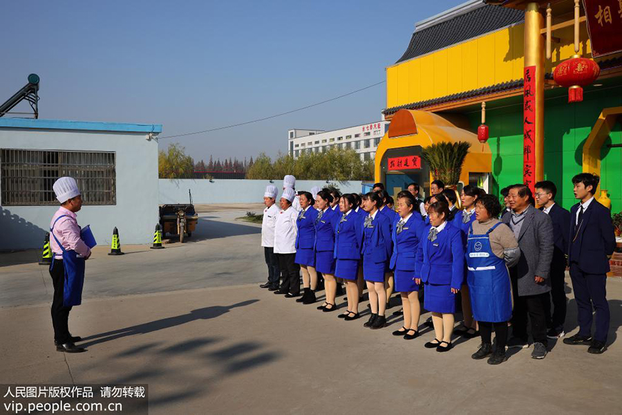 12月10日，郭峰在他的饭店门口给员工们开会。